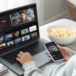 User streaming niche and international content on Premiumindo69 using a laptop and smartphone, symbolizing accessibility and unique streaming options.